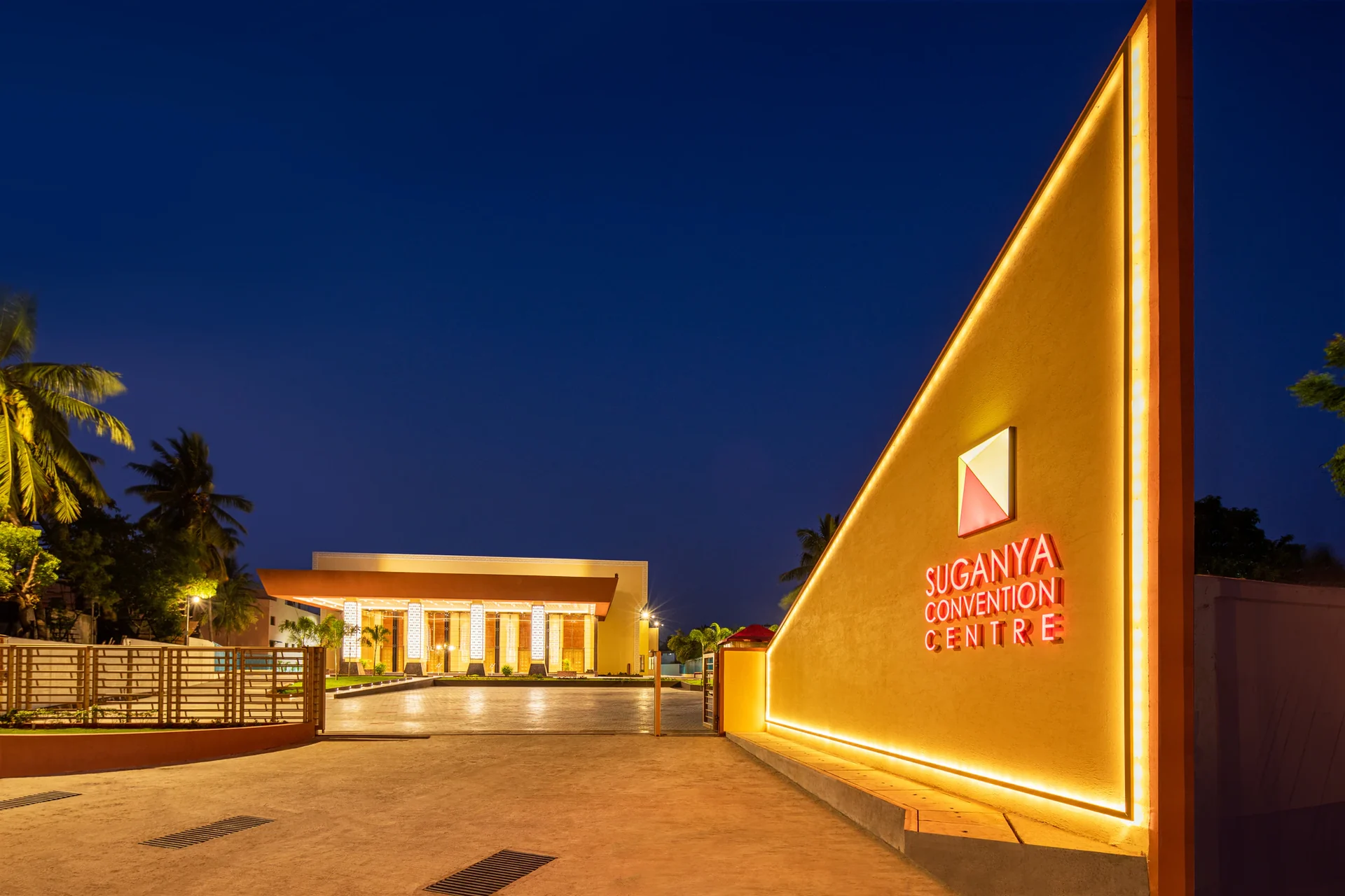 Illuminated façade of Suganya Convention Centre at dusk, Mudaliarpet, Pondicherry